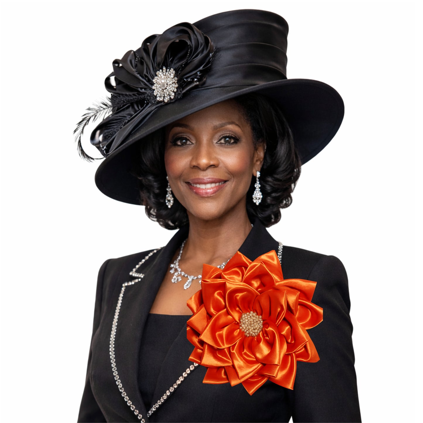 Vibrant orange satin floral corsage brooch worn on a black woman's lapel, featuring a statement floral design from Roni Accessories.